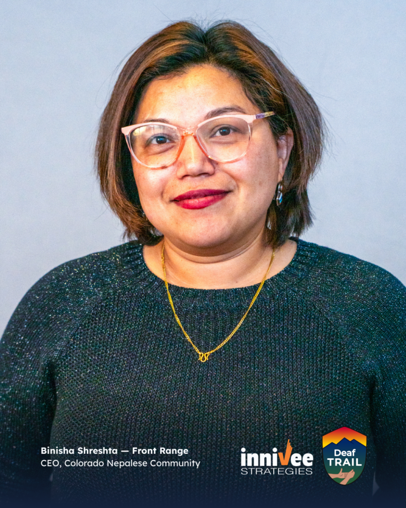 Deaf TRAIL Is Underway: Introducing Colorado’s First Cohort 2 Smiling headshot of a person with short brown hair and light-colored glasses, wearing a dark sparkly sweater and gold necklace against a light blue-gray background. Name and role text appears at bottom; inniVee Strategies and Deaf TRAIL logos at bottom right.