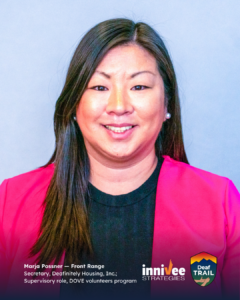 Smiling headshot of a person with long dark hair, pearl earrings, and a bright pink blazer over a dark top against a light blue-gray background. Bottom text lists name and roles; inniVee Strategies and Deaf TRAIL logos at bottom right.